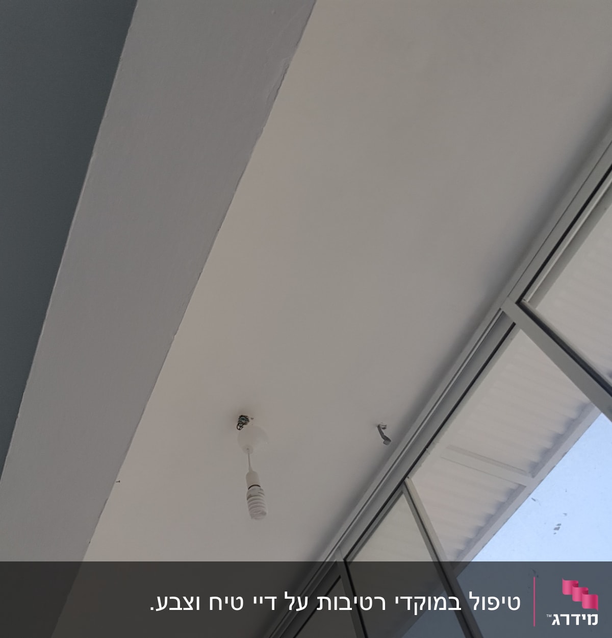 תקרה צבועה בלבן עם נורה תלויה